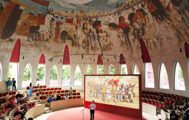 A mural from a local artist adorns the ceiling inside the agora